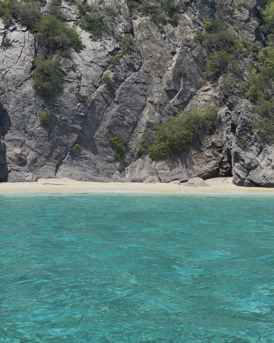 Una cala de agua turquesa al pie de un acantilado en la costa de Choroní