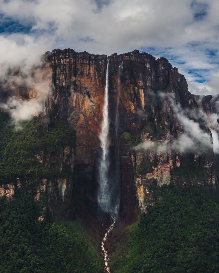El Salto Ángel cayendo por la pared vertical de un tepuy, entre nubes